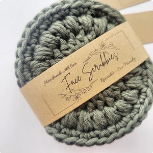 May include: A green crocheted face scrubbie with a brown paper label that says "Handmade with love Face Scrubbies Reusable - Eco Friendly".
