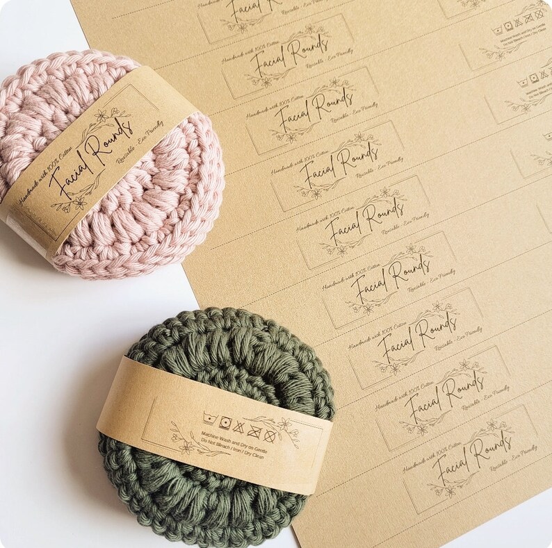 May include: Two crocheted facial rounds, one pink and one green, with brown paper labels. The labels have the text "Facial Rounds" and instructions for washing and drying.