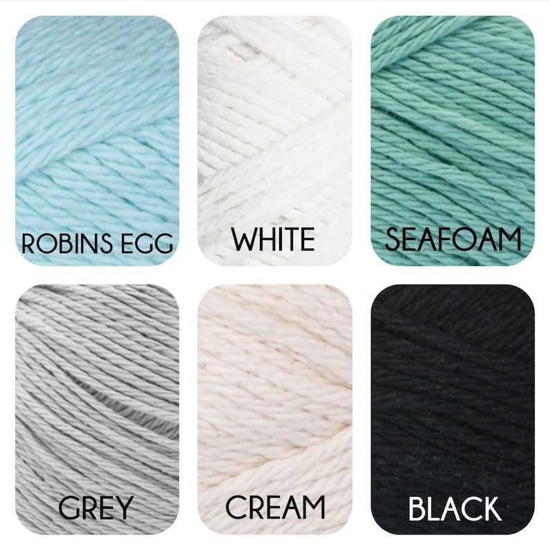 May include: Six skeins of yarn in different colours: robin's egg blue, white, seafoam green, grey, cream, and black.