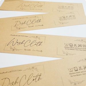 May include: Four brown paper tags with black text and floral designs. The tags are for washcloths and dishcloths. The text on the tags reads "Handmade with 100% Cotton", "Wash Cloth", "Reusable - Eco Friendly", "Dish Cloth", and "Machine Wash and Dry on Gentle, Do Not Bleach/Iron/Dry Clean".