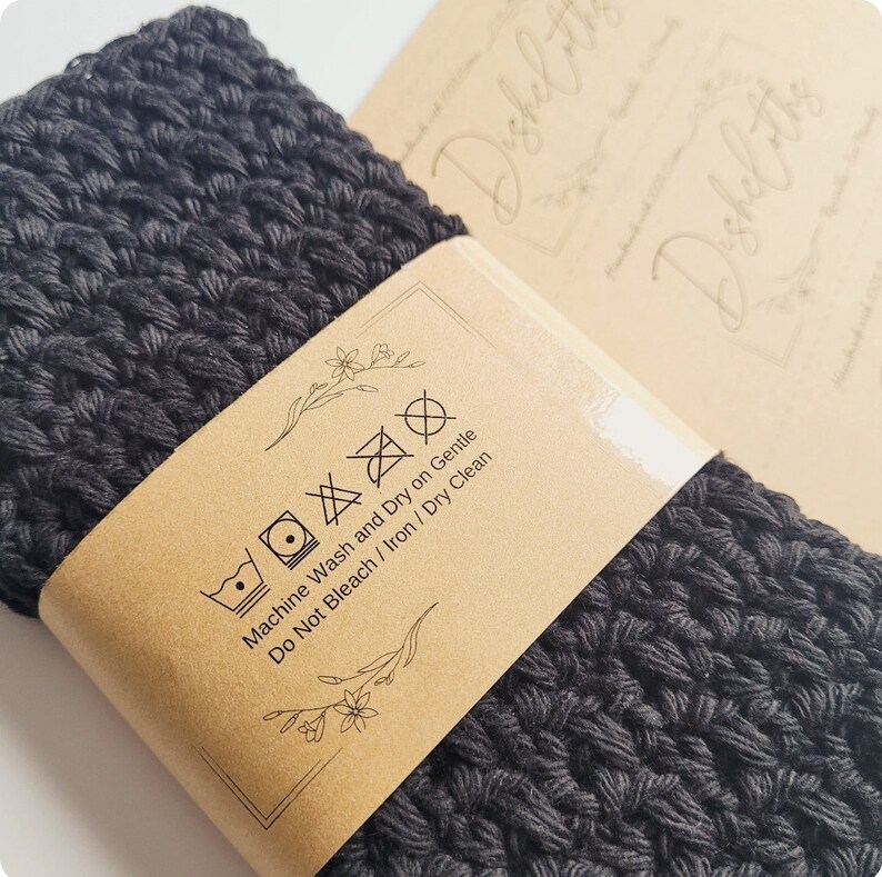 May include: A black crocheted dishcloth with a brown paper tag that says "Machine Wash and Dry on Gentle, Do Not Bleach / Iron / Dry Clean".