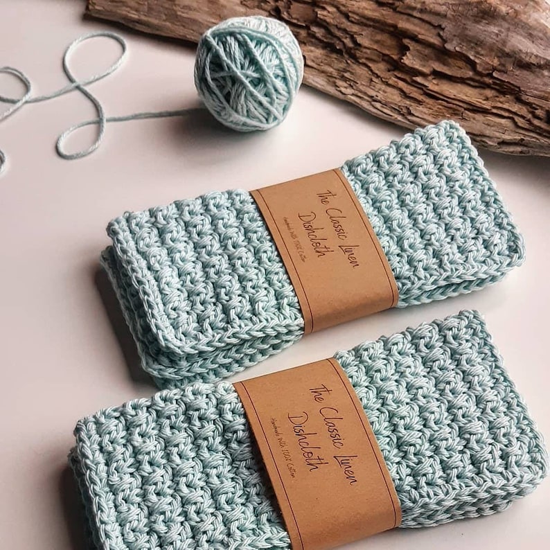May include: Two light blue linen dishcloths with brown labels that read "The Classic Linen Dishcloth Handmade with 100% Cotton".
