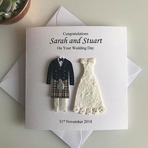 K&ouml;nnte beinhalten: Eine wei&szlig;e Karte mit einer Schwarzwei&szlig;illustration eines Brautpaares. Der Br&auml;utigam tr&auml;gt einen Kilt und die Braut ein wei&szlig;es Kleid. Der Text auf der Karte lautet "Herzlichen Gl&uuml;ckwunsch Sarah und Stuart Zu Eurem Hochzeitstag 31. November 2018".