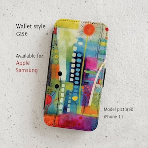 May include: A colourful abstract design phone case with a wallet style flap. The case is available for Apple and Samsung phones. The model pictured is an iPhone 11.