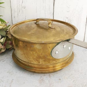 Olla de cobre antigua con tapa, cacerola sueca de latón, utensilios de cocina rústicos para fuego abierto.