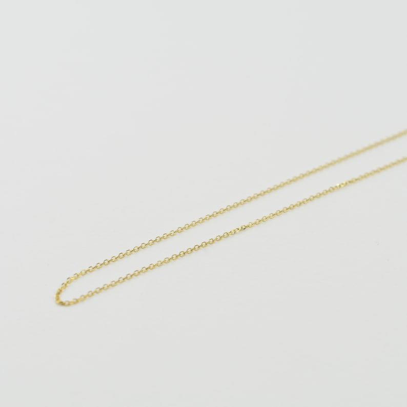 K&ouml;nnte beinhalten: Eine zarte goldene Kettenkette, perfekt zum Schichten oder allein tragen.