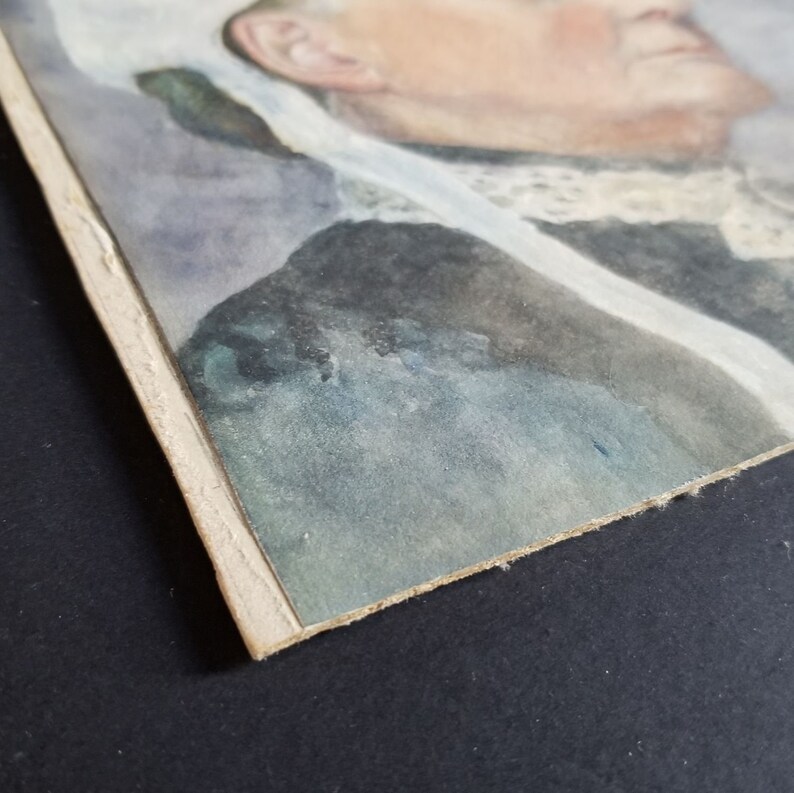 May include: A watercolour painting of a woman's portrait. The woman is wearing a white lace collar and a dark blue dress. The painting is framed with a light brown mount.
