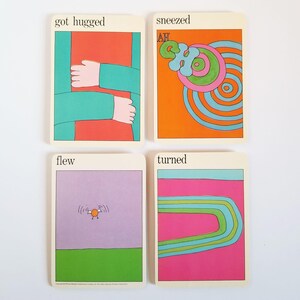 The reverse side of the same set of four cards. Each one has a colourful illustration of the verb printed in black across the top. The first card has the text 'got hugged'. The second card has the text 'sneezed' across the top. The third card has the text 'flew' across the top. The 4th card has the text 'turned' at the top.