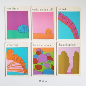The other side of the same set of 6 vintage rectangular cards with visual illustrations of action verbs and text in black across the top. The text on the cards reads 'was afraid', 'curled up in a ball', 'snored, 'screeched', 'hid under a rock', and 'dug a deep hole'. The cartoon style illustrations are very colourful and have a white border around the edges.