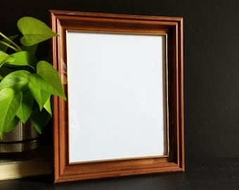 May include: A wooden picture frame with a gold trim. The frame is empty and ready for a photo or artwork.
