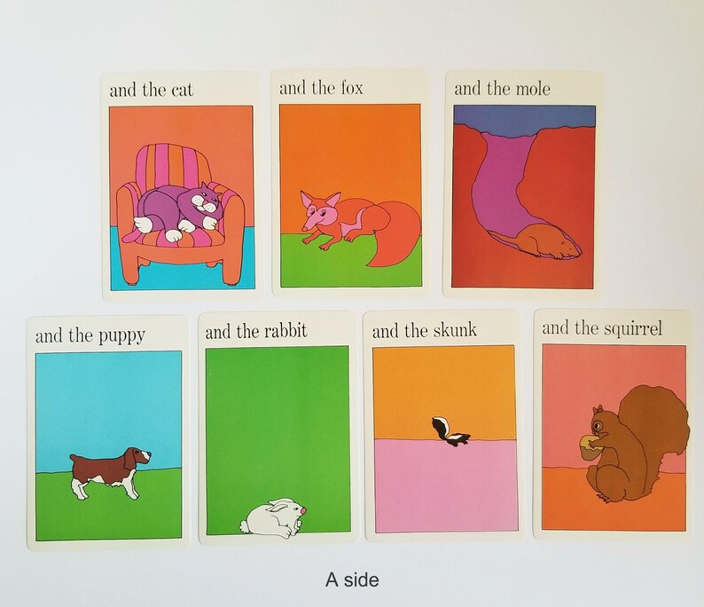 A set of 7 vintage rectangular cards with illustrations of animals and text on both sides. The text on the cards reads 'and the cat', 'and the fox', 'and the mole', 'and the puppy', 'and the rabbit', 'and the skunk', 'and the squirrel'. The cartoon style illustrations are very colourful and have a white border around the edges. The text is in black across the top.
