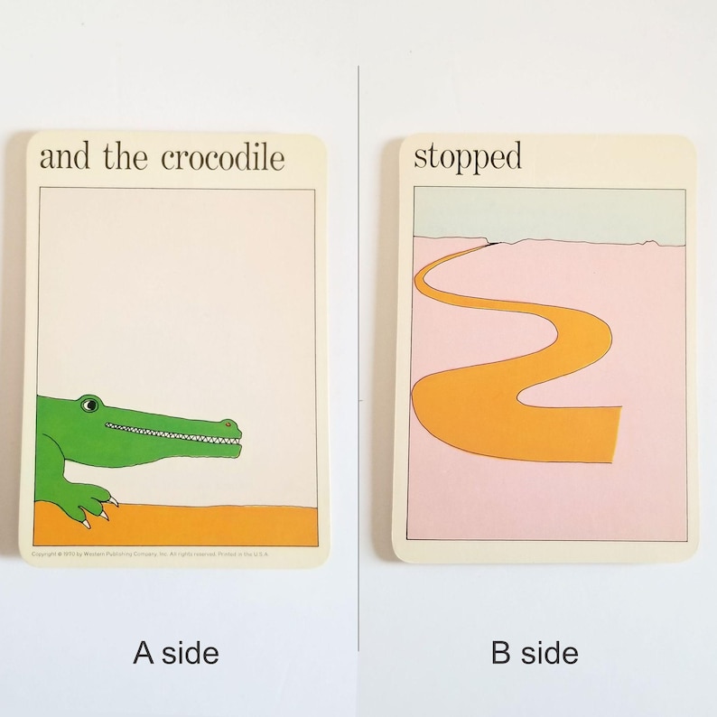 an image showing both sides of the same rectangular card. Side A has an illustration of a green smiling crocodile and the text 'and the crocodile' at the top. Side B has an illustration of an orange winding road on a pink background and the text 'stopped' at the top.