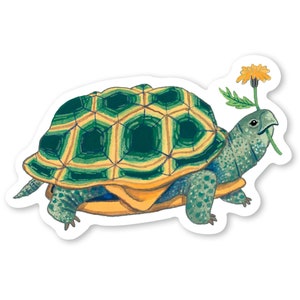 May include: A green and yellow turtle with a yellow flower in its mouth. The turtle is walking on a white background.