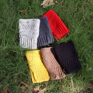 May include: Six crocheted fingerless gloves in different colors: white with speckles, dark gray, red, yellow, brown, and black.