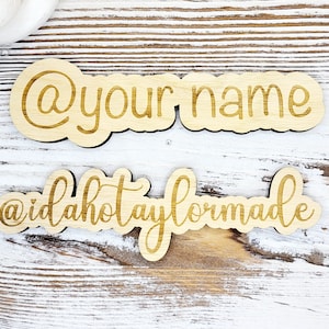 May include: Two wooden signs with the text "@your name" and "@idahotaylormade" in gold lettering.