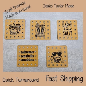 May include: Five square wooden coasters with beach-themed designs and text. The coasters feature phrases like "Beauty and the Beach," "Beach Dreams," and "Happy and Salty." Each coaster has a series of small holes around the edges.