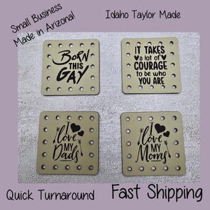 May include: Four square coasters with various black text designs. One reads "Born This Gay", another says "It takes a lot of courage to be who you are". The other two say "I love my Dads" and "I love my Moms".