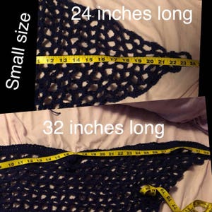 May include: Two crocheted triangle shawls in navy blue. The smaller shawl measures 24 inches long and the larger shawl measures 32 inches long.