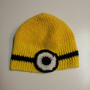 May include: Yellow crocheted hat with a black and white eye design.