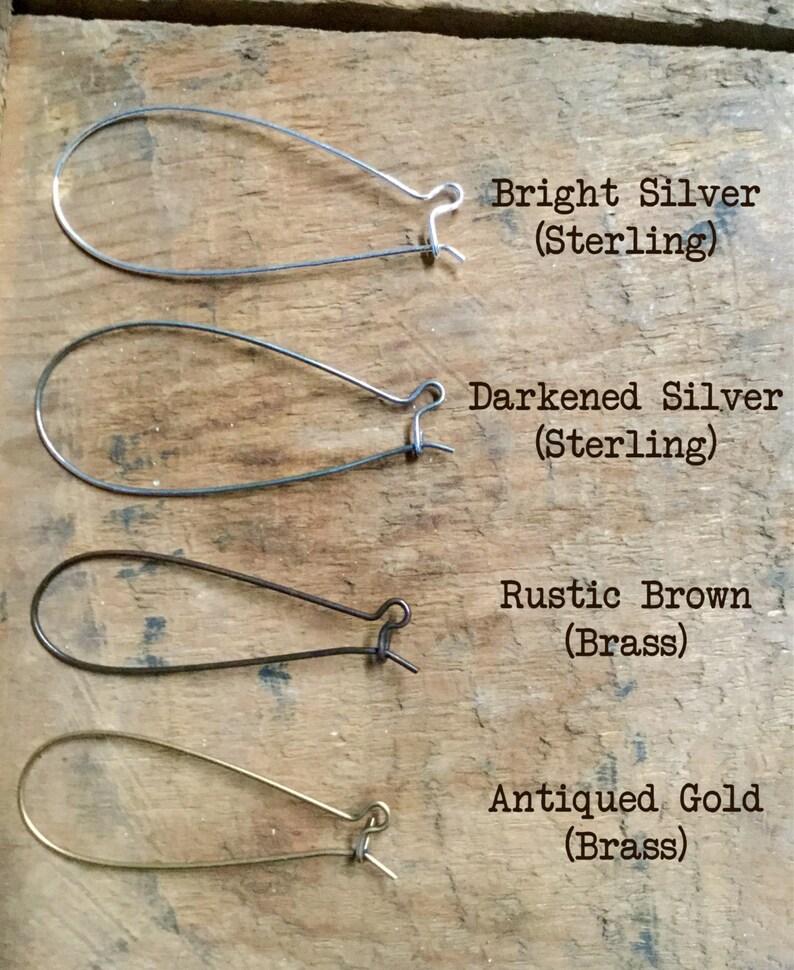 May include: Four different earring styles: bright silver, darkened silver, rustic brown, and antiqued gold. Each earring is a simple, teardrop-shaped hoop.