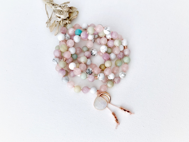 mala beads necklace with pink white light green and blue hues. meditation necklace knotted with nylon cord between each bead. moonstone guru crystal and moon charm