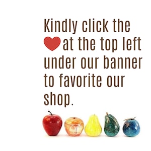 May include: The image features a row of decorative fruit sculptures in various colors, including red, yellow, green, and blue. Text above the fruit reads, "Kindly click the heart at the top left under our banner to favorite our shop."