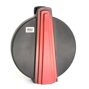 Può includere: Un vaso in ceramica nera con corpo circolare e design geometrico verticale rosso. Il vaso ha un'etichetta rettangolare con la scritta "BAY. KERAMIK."