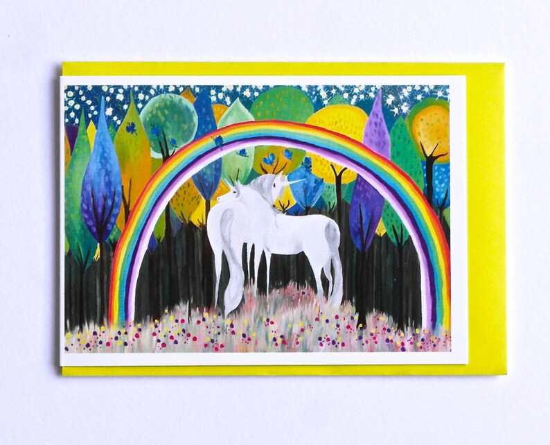 May include: Two white unicorns stand under a rainbow in a forest with colorful trees and a starry night sky.