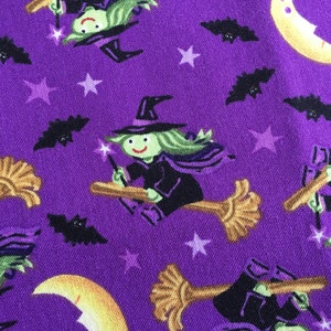 Peut inclure: Tissu violet avec un motif répété de sorcières volant sur des balais, des chauves-souris, des étoiles et des croissants de lune. Les sorcières portent des chapeaux et des robes noirs et ont la peau verte et des visages souriants.