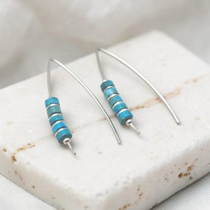 May include: A set of three ceramic mugs with a speckled, matte finish. The mugs are in shades of cream, light gray, and dark gray. Each mug has a simple, minimalist design, perfect for coffee or tea.