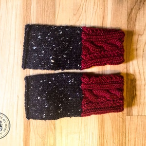 May include: A pair of black and white knit fingerless gloves with red cable knit cuffs.