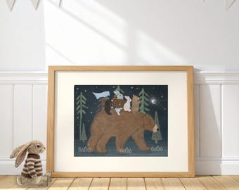 May include: A framed art print featuring a large brown bear walking through a dark forest at night. A smaller bear, a rabbit, and a badger ride on the bear's back. The scene includes a light blue flag, green pine trees, and a crescent moon.
