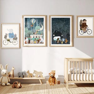 May include: Four framed wall art prints featuring whimsical animal illustrations, including an elephant on a bicycle, a forest camping scene with a camper van, a night scene with a campfire, and a bear riding a bicycle with a stack of books.