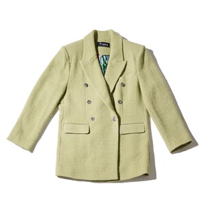 May include: A light green double-breasted blazer with silver buttons. The blazer has a textured fabric and a small label that says "Freaks" on the left side of the collar.