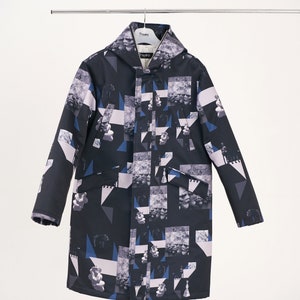 Puede incluir: Una chaqueta negra con capucha con un estampado geom&eacute;trico y abstracto en tonos azules, blancos y grises. La chaqueta tiene una cremallera y dos bolsillos.