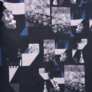 Puede incluir: Tela estampada en blanco y negro con formas geom&eacute;tricas e im&aacute;genes de rostros, figuras y animales. La tela tiene un fondo oscuro con una textura sutil.