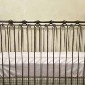 Pu&ograve; includere: Una culla in stile vintage con struttura in metallo. La culla presenta un materasso bianco e una gonna e fiocchi a quadretti verdi e bianchi. Il design della culla &egrave; classico ed elegante, adatta a una cameretta.