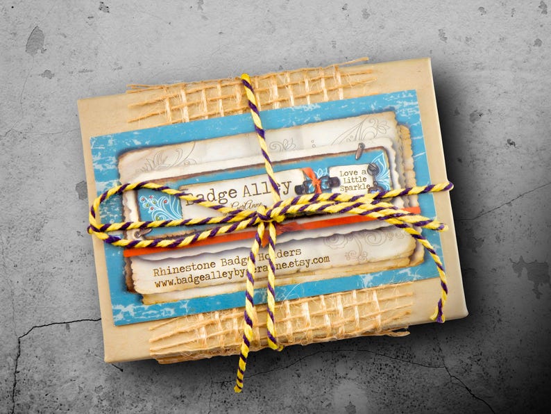 a package wrapped in a yellow and blue twine, tied with a yellow string, and placed on a concrete surface.