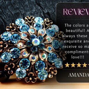 a beautiful blue and gold brooch with intricate designs and sparkling gemstones, placed on a dark surface.