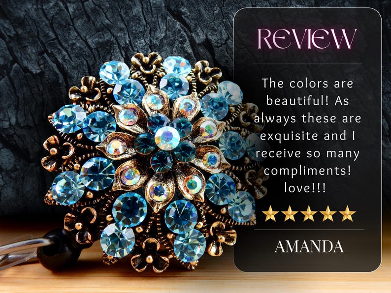 a beautiful blue and gold brooch with intricate designs and sparkling gemstones, placed on a dark surface.