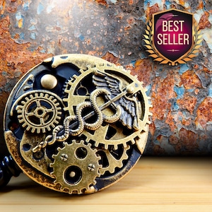Puede incluir: Un portatarjetas de estilo steampunk con un dise&ntilde;o de engranajes y un s&iacute;mbolo m&eacute;dico de caduceo. El portatarjetas es dorado y negro, con un emblema de "Best Seller". El fondo es una superficie oxidada y texturizada.