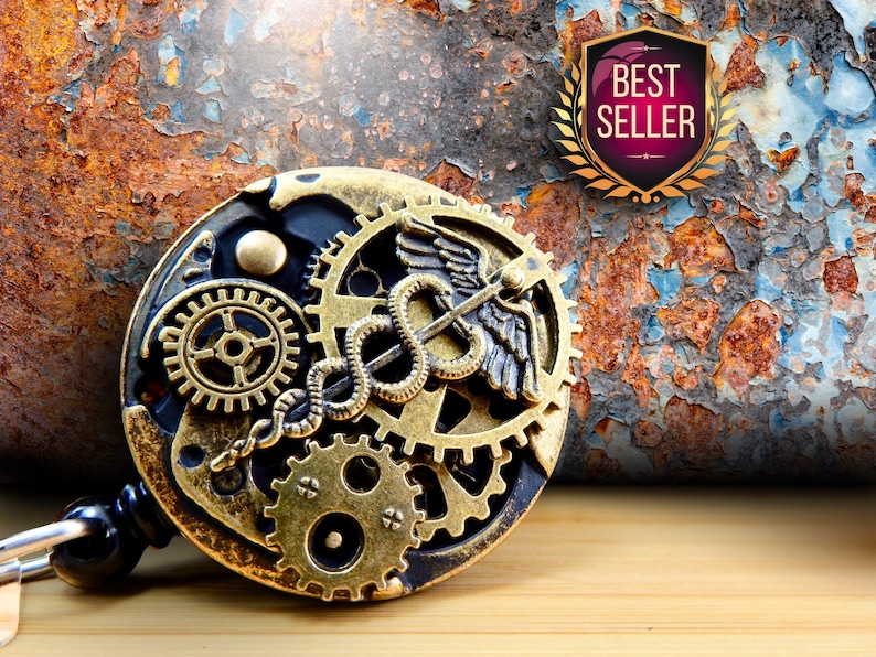 Puede incluir: Un portatarjetas de estilo steampunk con un dise&ntilde;o de engranajes y un s&iacute;mbolo m&eacute;dico de caduceo. El portatarjetas es dorado y negro, con un emblema de "Best Seller". El fondo es una superficie oxidada y texturizada.