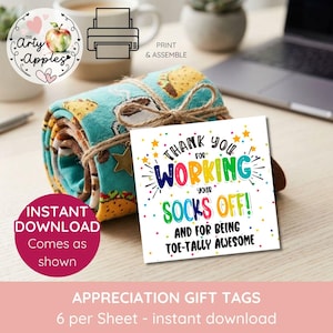 May include: A pair of rolled teal socks featuring a taco pattern, tied with twine and a gold star charm. A square white gift tag is attached, printed with colorful text that reads: Thank you for working your socks off and for being toe-tally awesome.