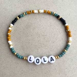 Pulsera con nombre personalizada - Cuentas en crema, ocre, negro, eucalipto y dorado - Joyería personalizada - Pulseras elásticas de la amistad - Joyería con palabras