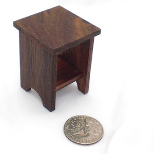 May include: A small wooden end table with a single shelf. The table is dark brown and has a simple design.