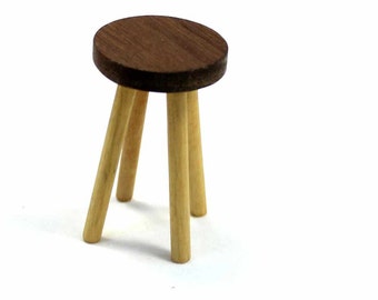May include: A small wooden stool with a round brown top and three light brown legs.