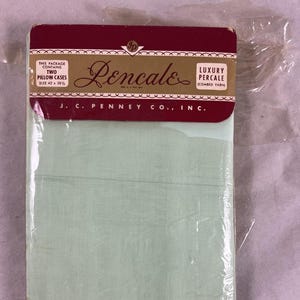 May include: A package of two mint green pillowcases, size 42 x 38.5 inches, from J.C. Penney Co., Inc. The packaging features a burgundy header with the brand name "Rencale" and the words "Luxury Percale (Combed Yarn)."