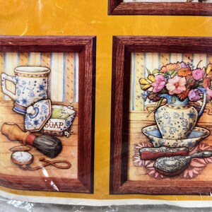 May include: Two framed pictures with a vintage aesthetic. The picture on the left shows a blue and white patterned mug, a soap dish, a shaving brush, and a pocket watch. The picture on the right shows a blue and white patterned vase with a bouquet of flowers, a blue and white patterned bowl, and a silver hairbrush.