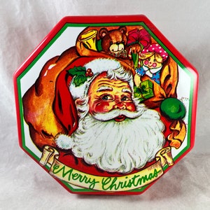 May include: Red and green octagonal tin featuring a vintage illustration of Father Christmas carrying a sack of toys. The sack contains a teddy bear, a doll, and a toy trumpet. The text "Merry Christmas" is written on a banner below Father Christmas.