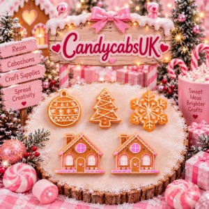 May include: A set of five gingerbread-style ornaments featuring a round bauble, a Christmas tree, a snowflake, and two houses with pink accents. The items are arranged on a round wooden slice covered in artificial snow, surrounded by holiday decor.